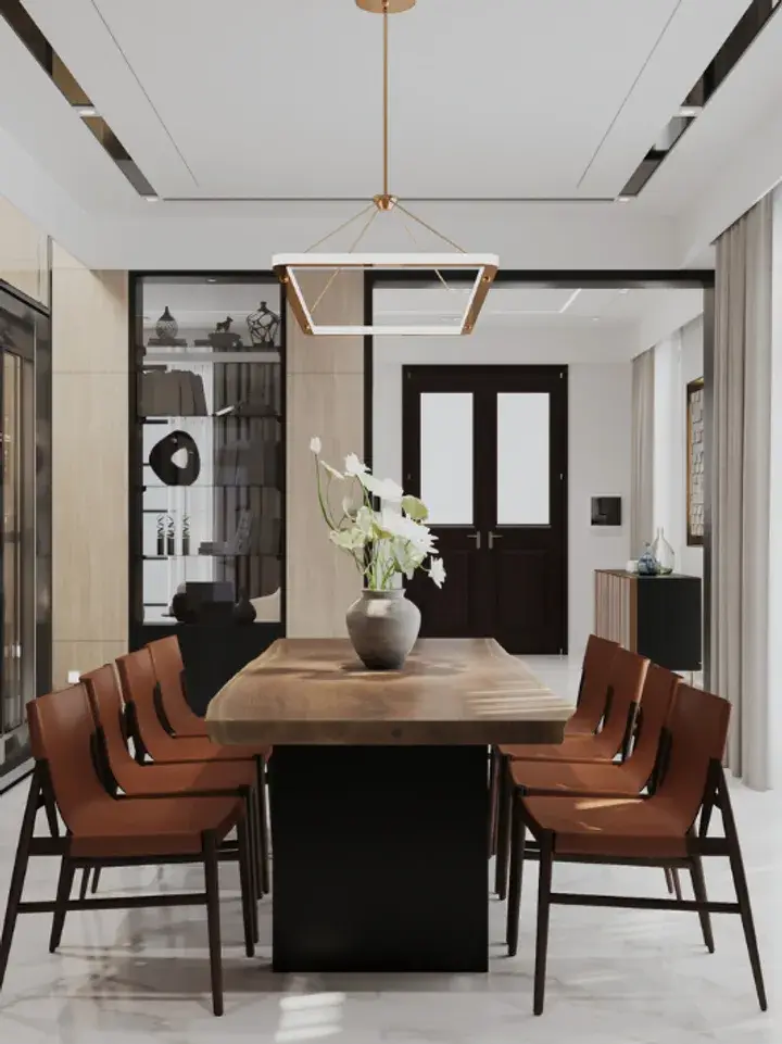A dining room with a long wooden table, tan leather chairs and a pendant light