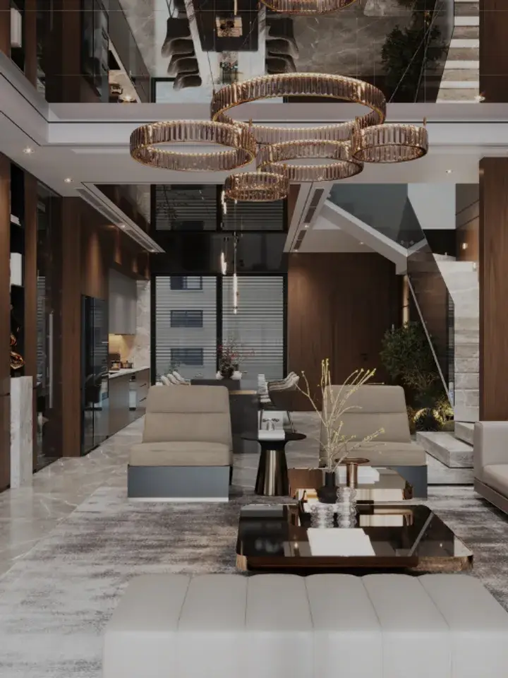 A double-height living room with a ring chandelier, a long sofa and marble walls